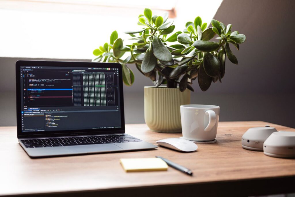 Crafting Captivating Headlines: Your awesome post title goes here A modern workspace featuring a laptop, mouse, and plant on a wooden desk by a window.